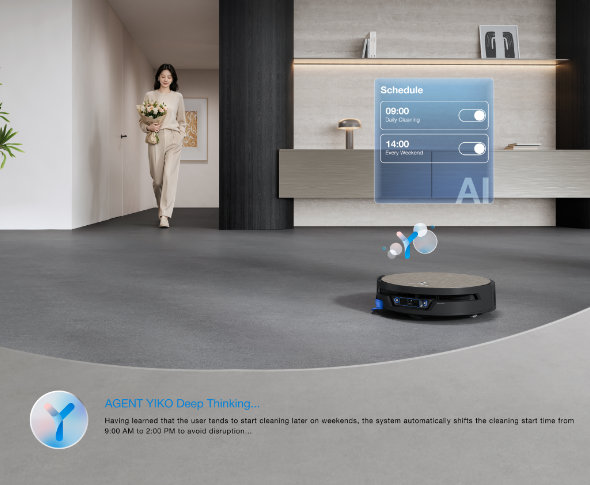 Robot Deebot sprząta salon, widoczna wizualizacja z aplikacji pokazująca harmonogramy sprzątania, na drugim planie kobieta niesie kwiaty