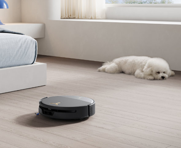 Robot odkurzający DEEBOT T90S Pro odkurzający a w tle śpiący zwierzak